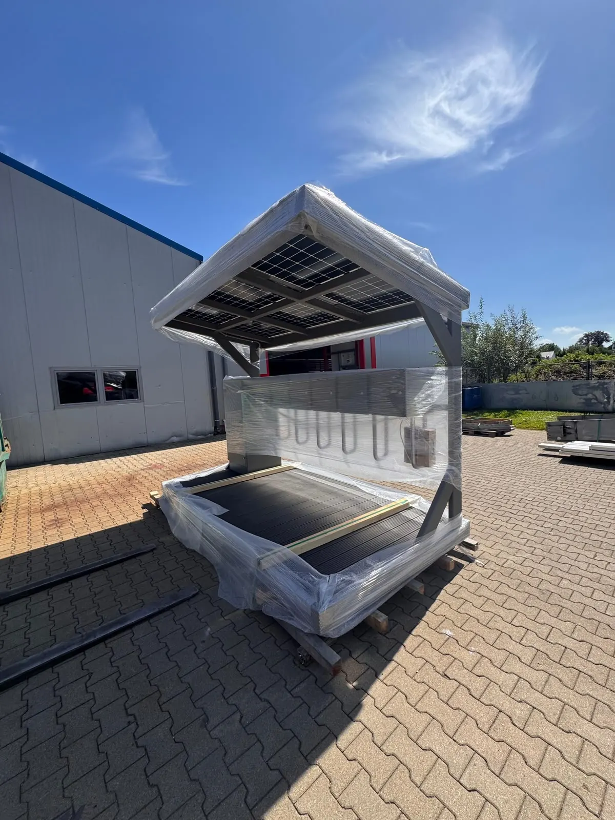 Transportbereit verpackte L.me Solar-Ladestation vor der Werkhalle