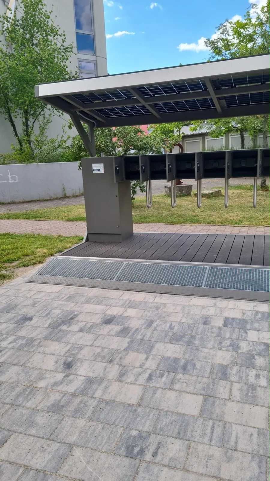 L.me Solar-Ladestation mit Solardach auf einer Pflasterfläche